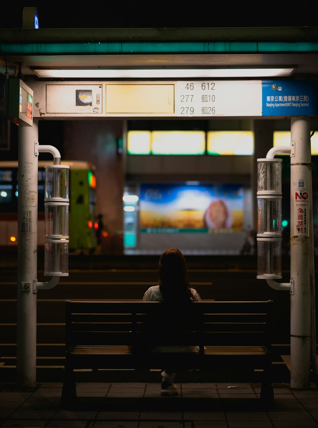 Commuters waiting at a public bus stop in the city