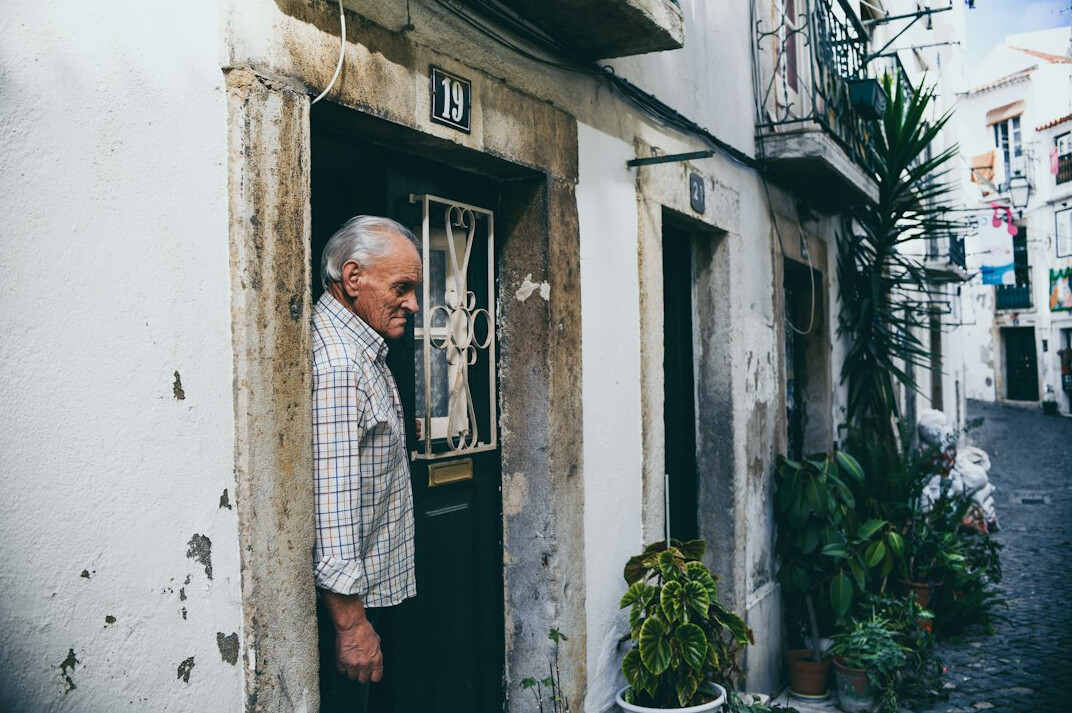 elderly man sitting on doorstep