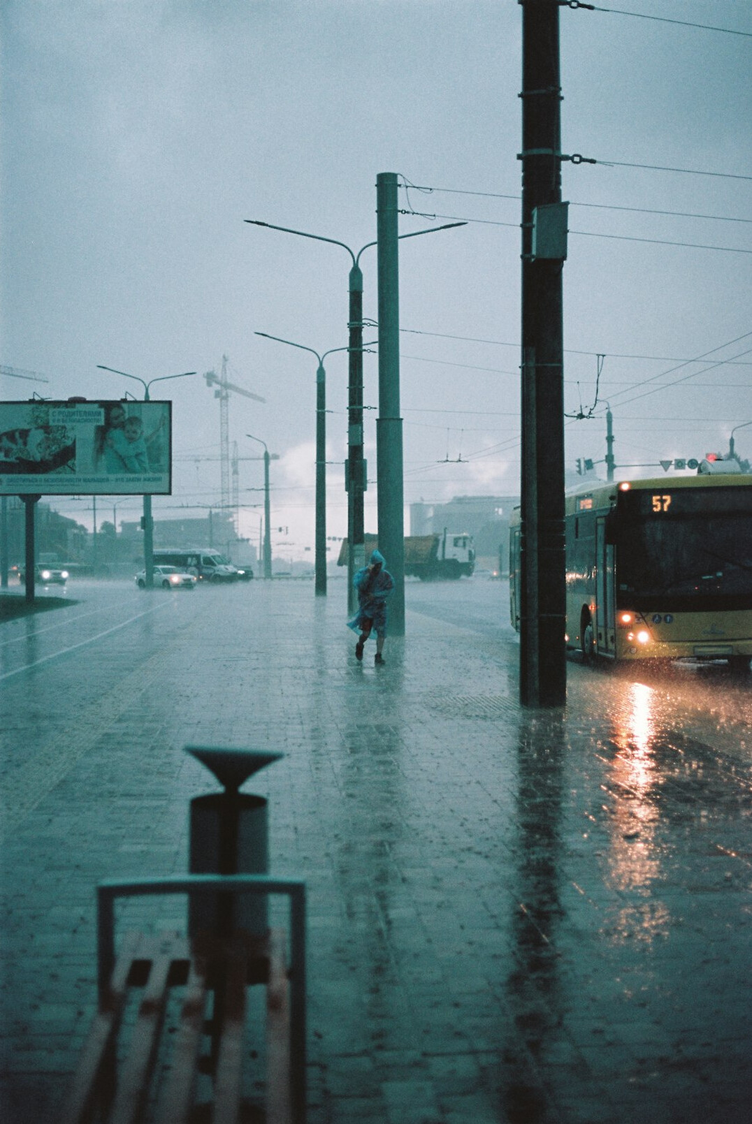 person waiting at bus stop in rain